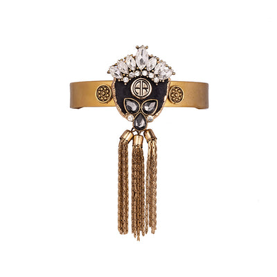 alt= "Statement bohemian gold cuff with black agate crystal and metal tassel detailing"